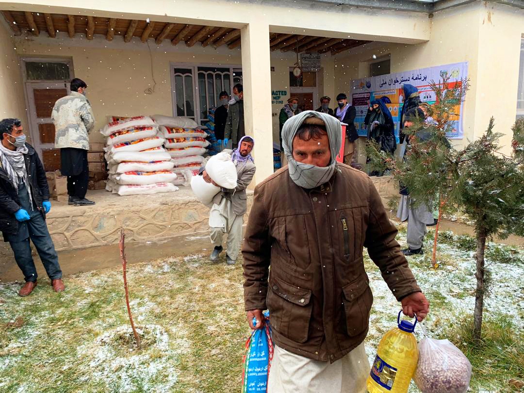 A beneficiary of Dastarkhwan-e Meli carrying the Relief Package in Badakhshan