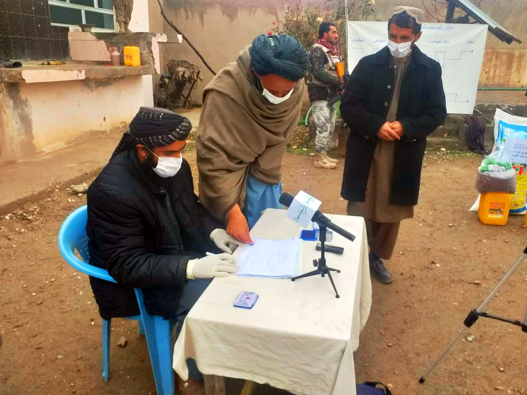 A beneficiary of the Dastarkhwan-e Meli Program puts his finger print for verification process